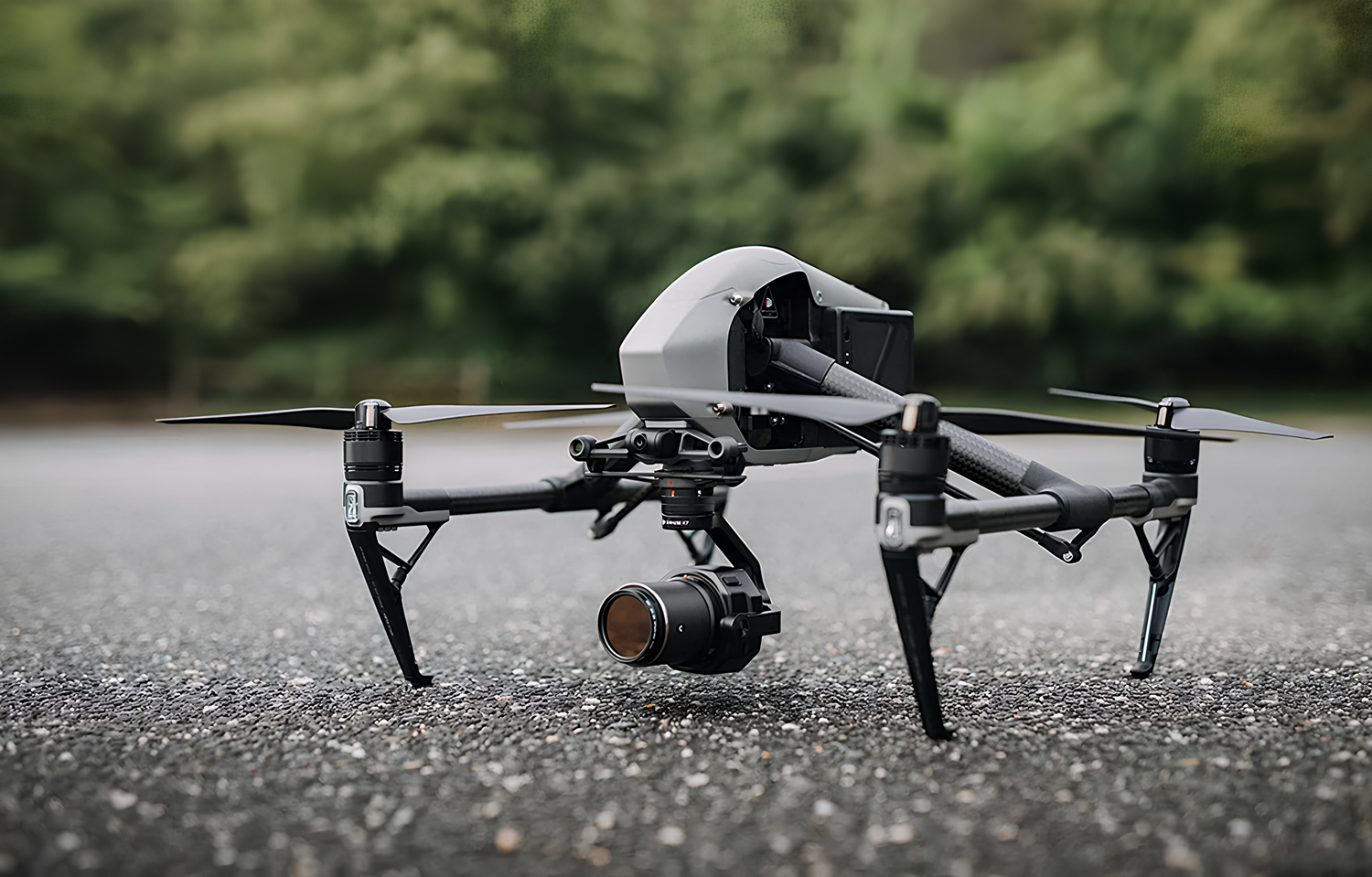DJI Inspire drone with camera mounted on ground against blurred natural background.