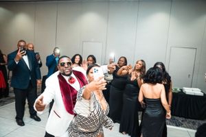 People in formal attire dancing and celebrating at an elegant event.