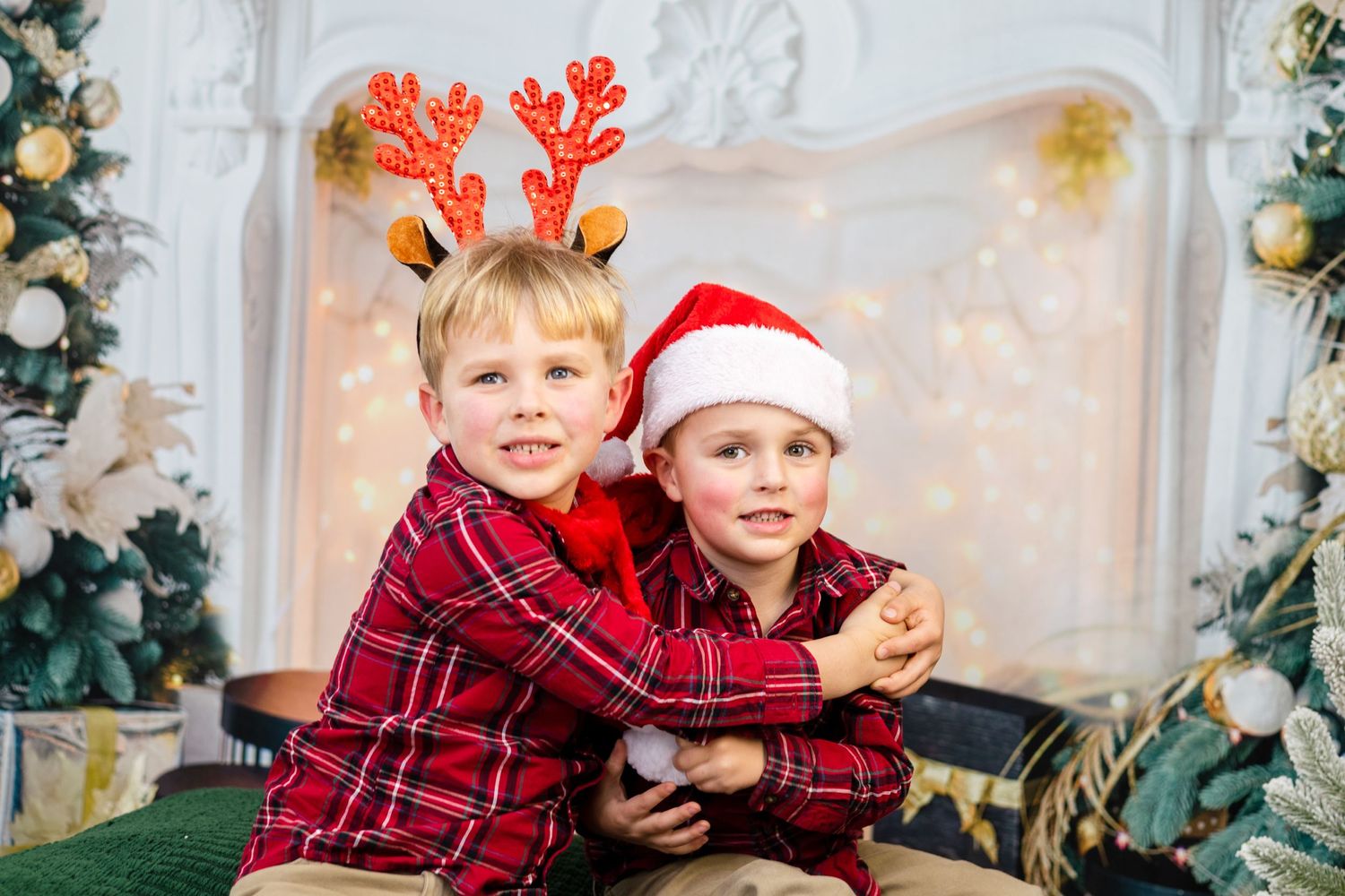 Children in matching plaid outfits pose for Christmas photos near decorated fireplace.