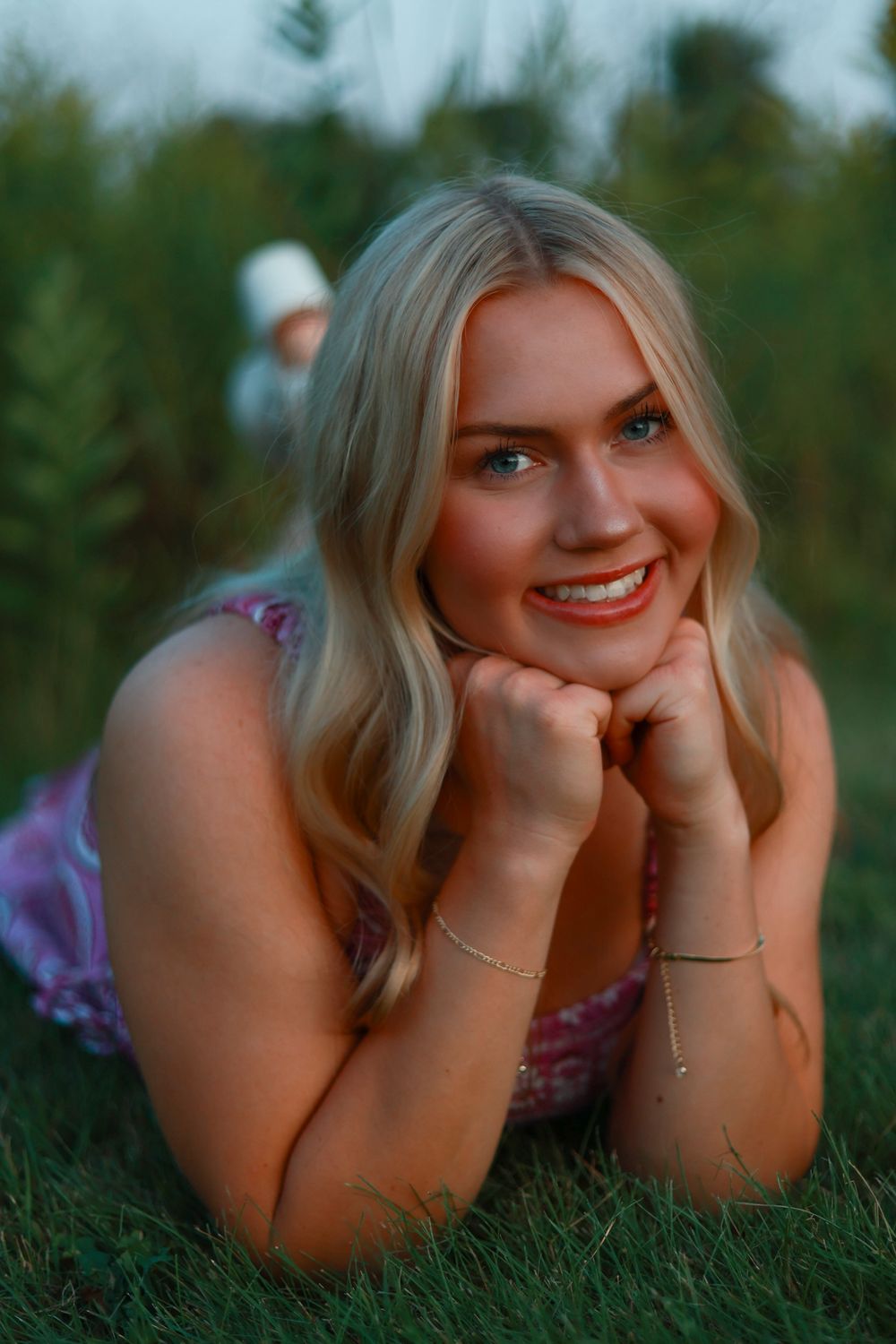 Portrait of person lying in grass during golden hour.