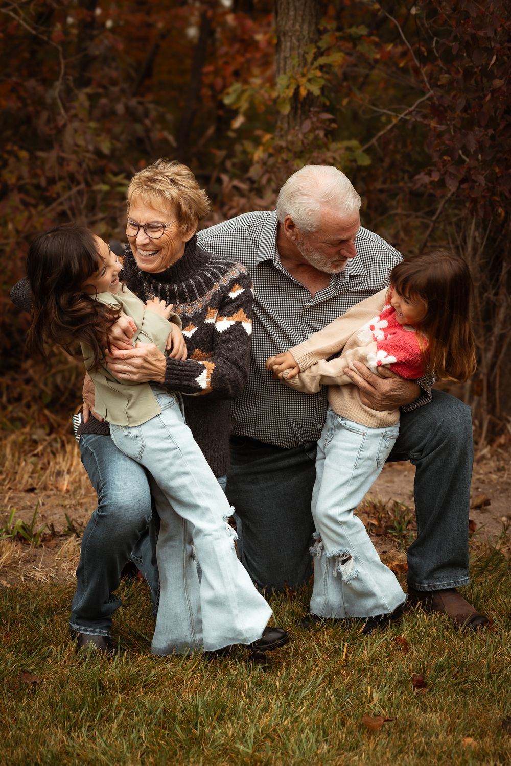 Family sharing playful moment together outdoors during autumn season.