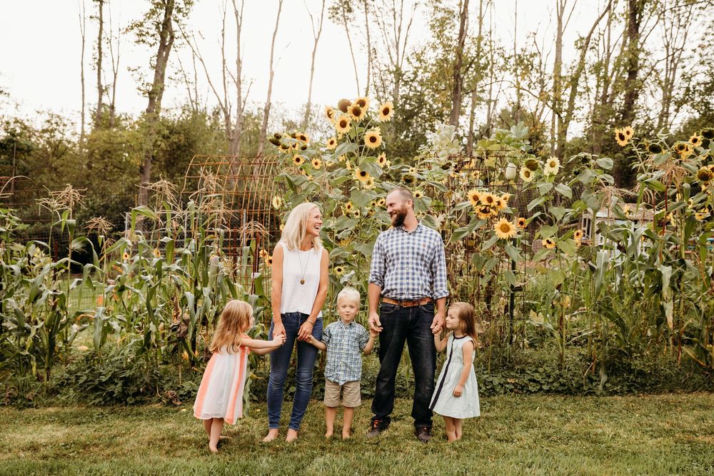 A family walking together through a garden path surrounded by trees and natural scenery.