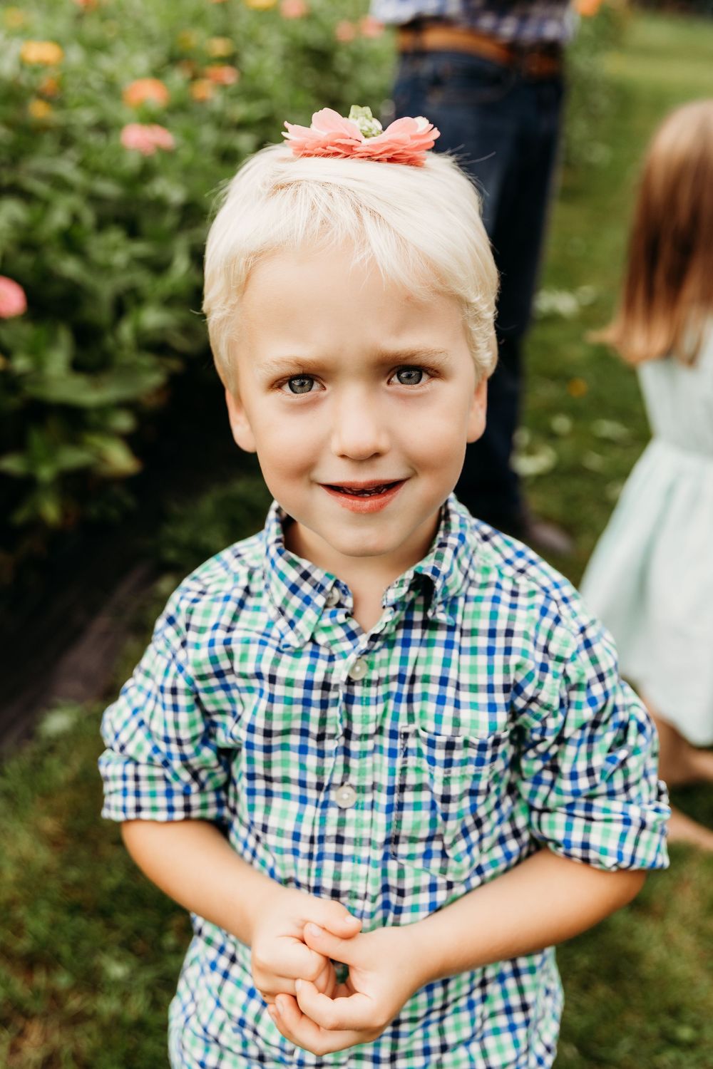 Playful portrait session in a lush garden setting with bright summer flowers.