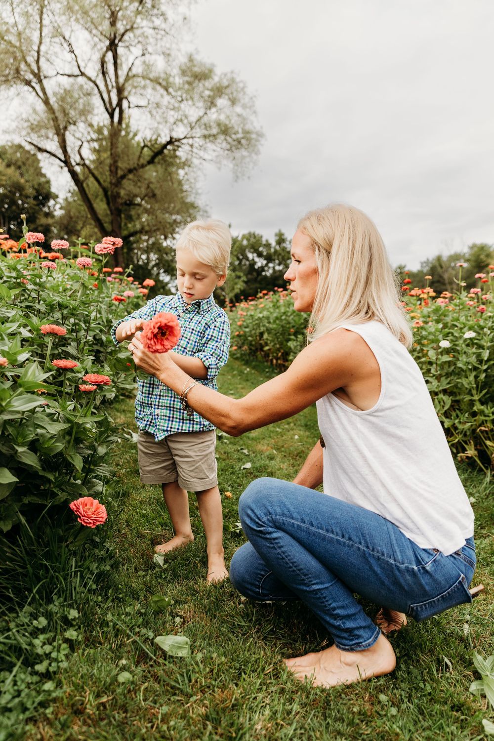 People exploring and interacting with beautiful blooming flowers in a summer garden.