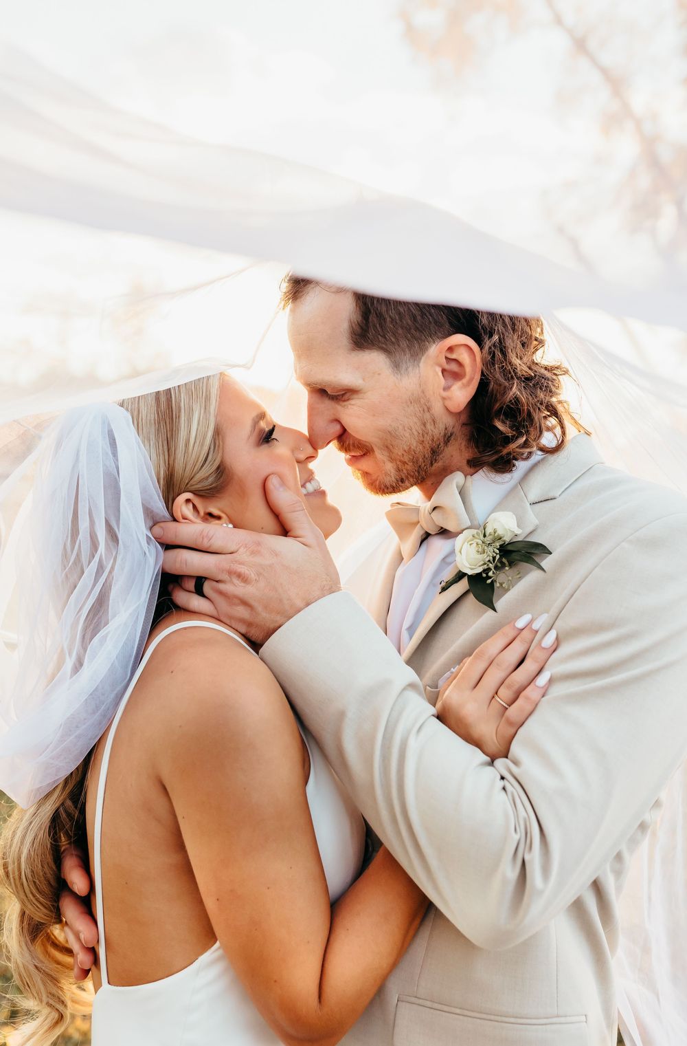 Intimate close-up of newlyweds sharing romantic moment in soft natural light.