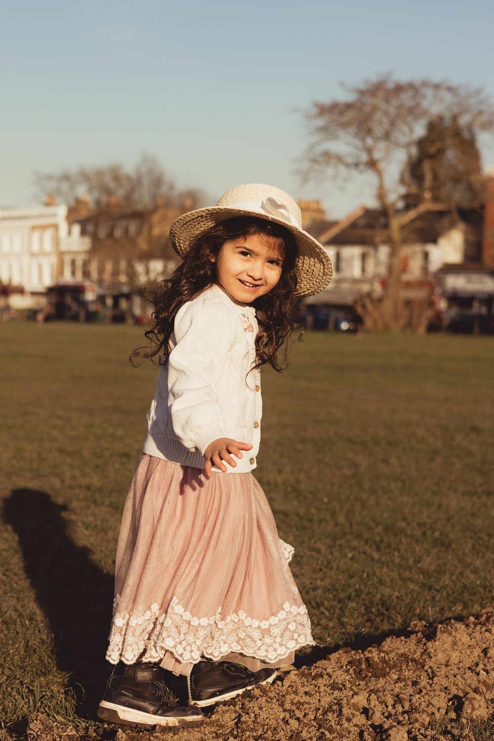 girl with a hat walking across a log