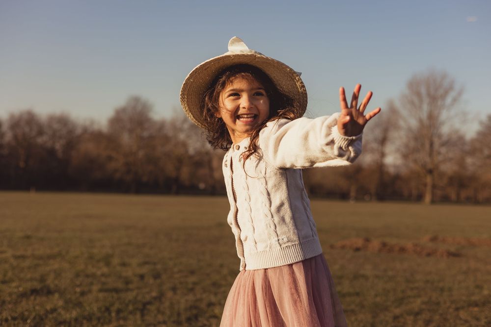 girl with a hat smiling outside