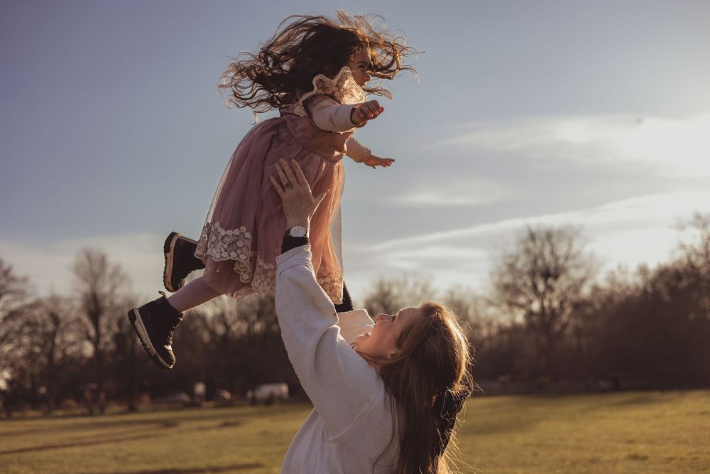 girl thrown in the air by her mum