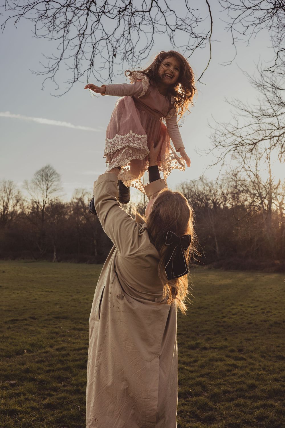mum throws girl in the air outdoors