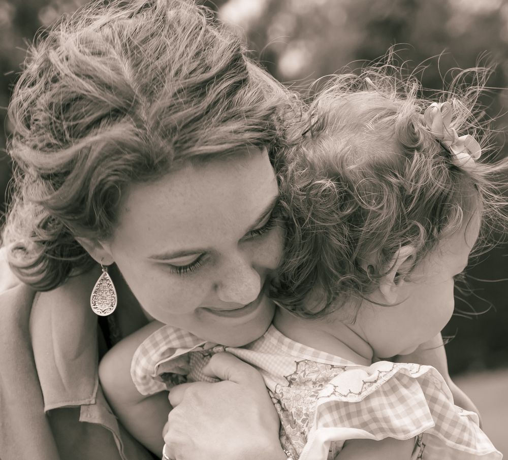 A gentle moment captured in black and white as parent and child share a tender embrace.