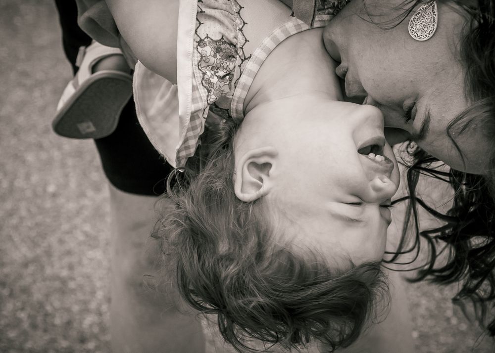 A black and white artistic photo showing two people close together in an intimate embrace with heads bent back.