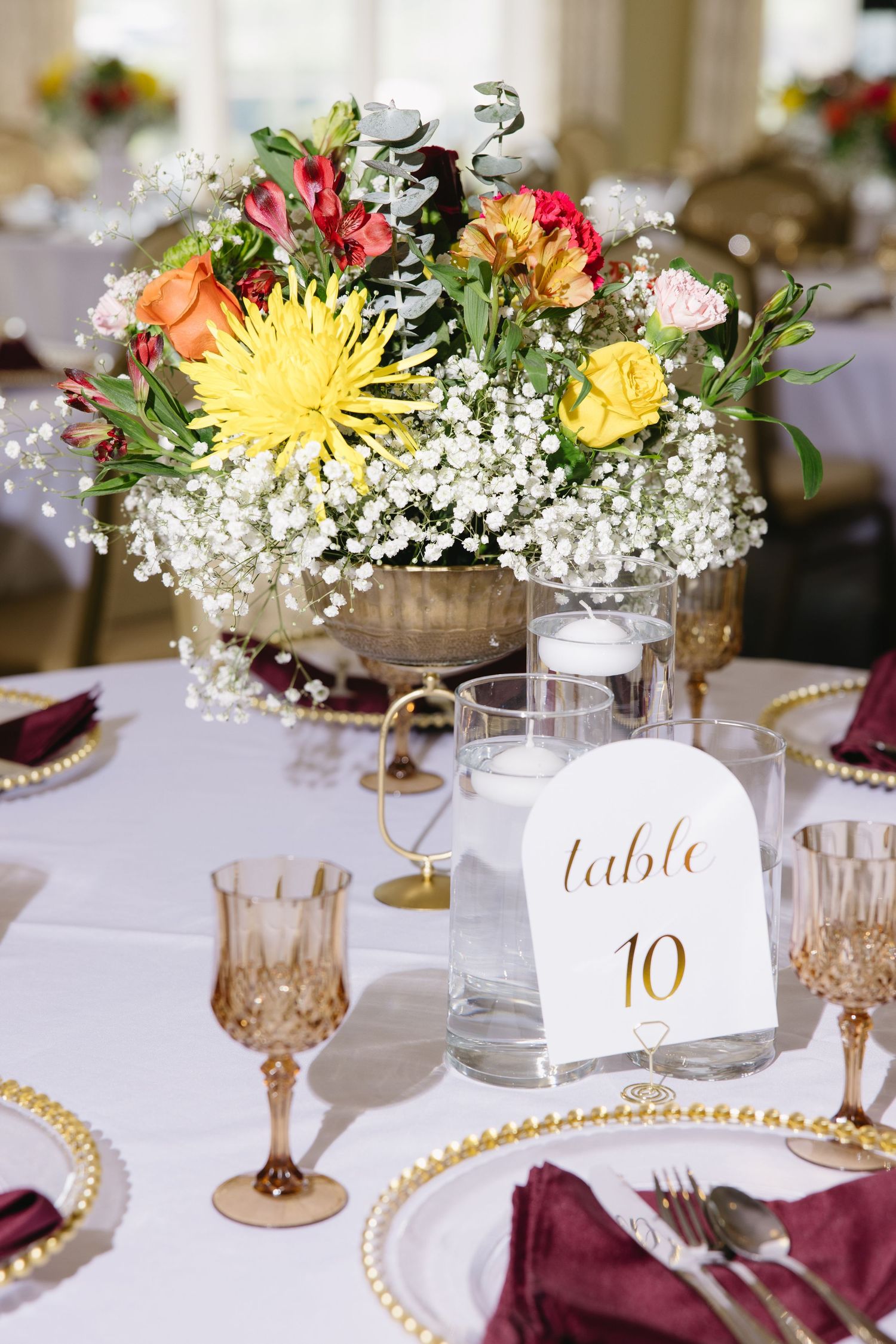 Delicate arrangement of peach roses and dahlias with wheat stems on white background.