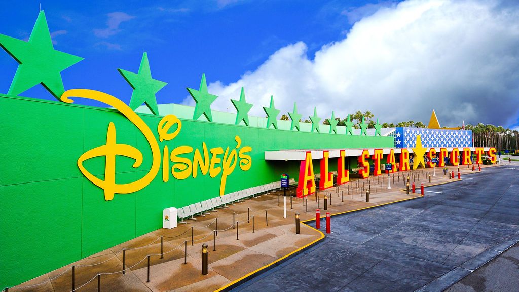 Exterior view of Disney's All-Star Sports Resort entrance with green wall and star decorations.