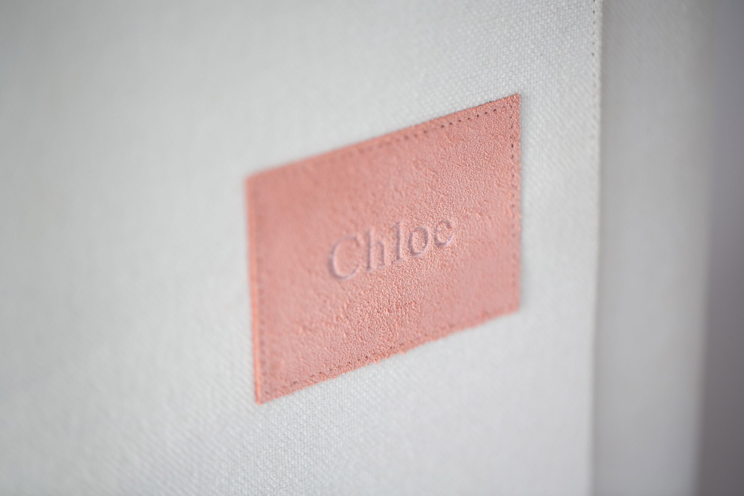 Blurry text in soft pink appears against a white background with a shallow depth of field effect.