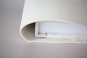 Close-up macro shot of white foam material with curved edge showing folded layered texture.