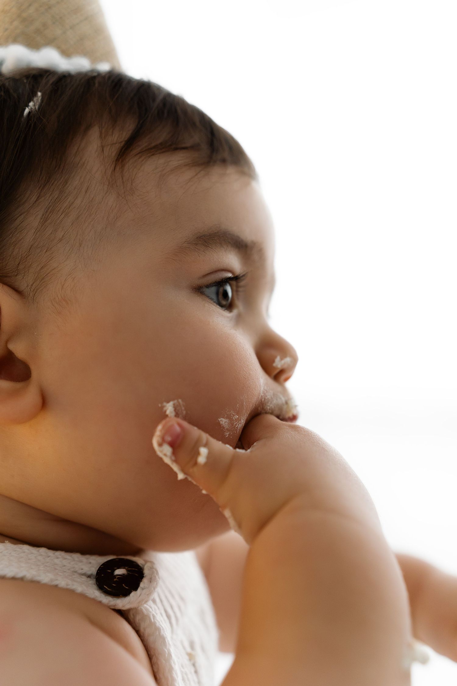 Close-up profile view of a young toddler with messy food around their mouth.