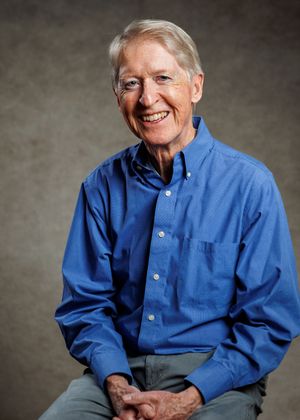A sequence of five portraits showing someone in a blue button-down shirt smiling progressively wider against a gray backdrop.