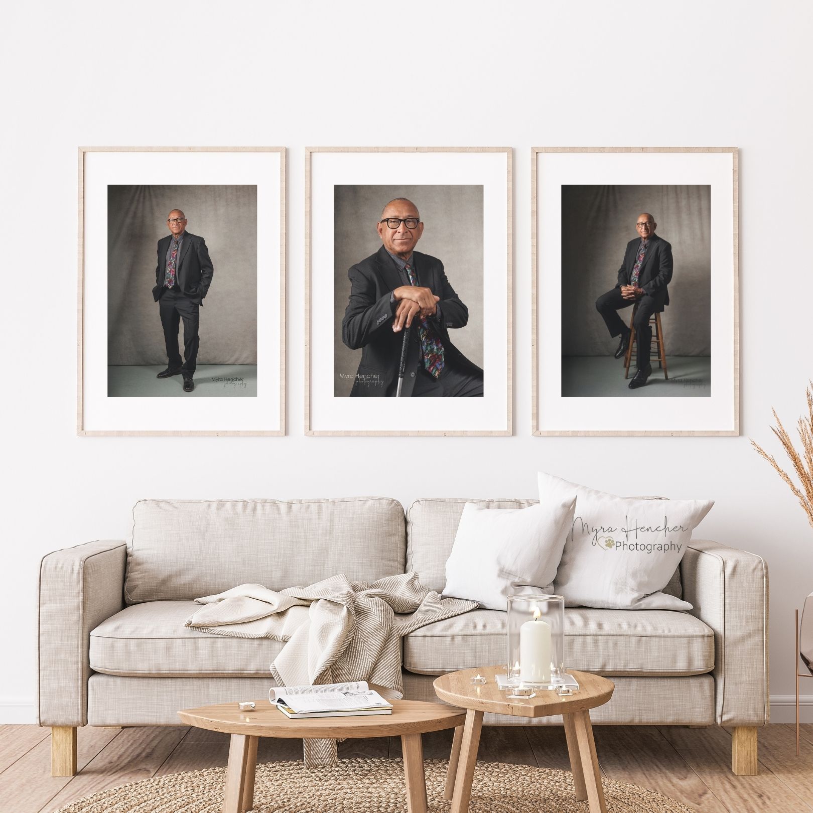 Modern living room interior with three framed portrait photographs above a beige sofa and wooden coffee tables.
