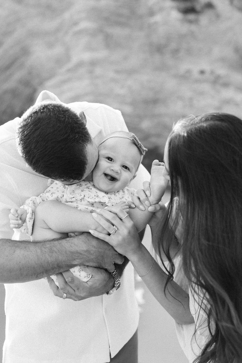 Parent and small child share a tender moment in black and white photography series.