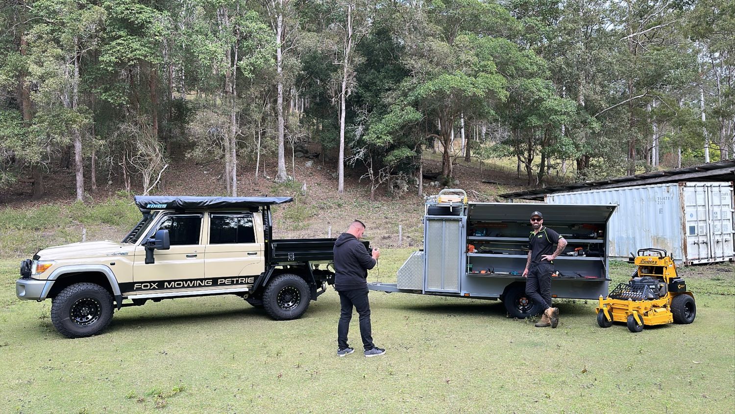 Trailer being delivered to a rural property with trees in the background.