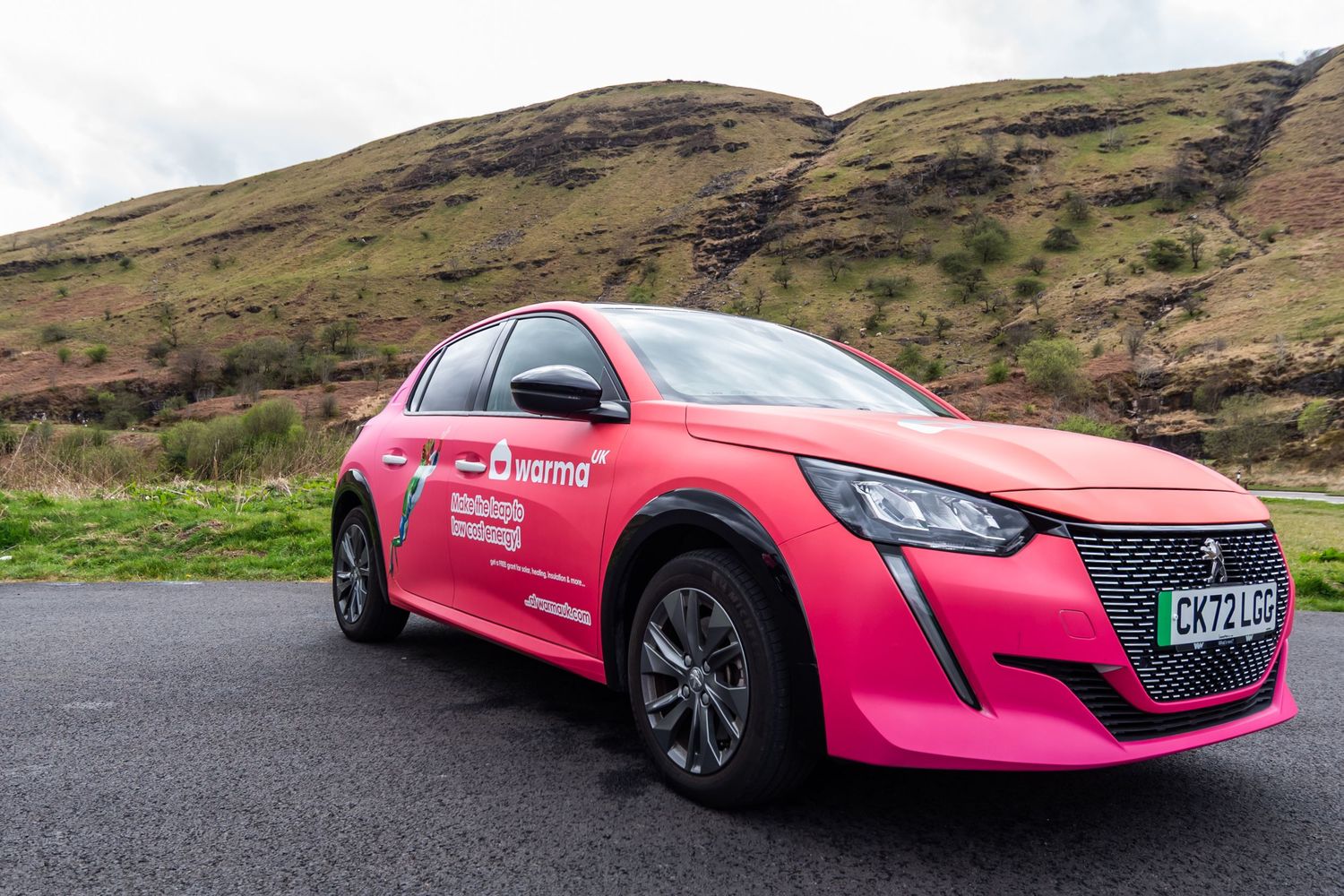 Pink branded sports car photographed from multiple angles against scenic hillside backdrop.