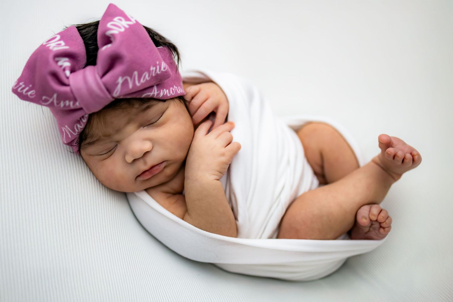 Baby wrapped and posed in newborn photo session in a studio in Brandermill, Midlothian, Richmond, VA. Newborn studio photographer RVA