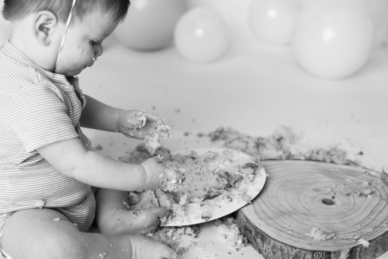Small hands press into a soft cake or dough surface creating decorative patterns and textures.