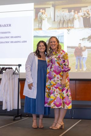 Feet view of two people in contrasting casual outfits - one in colorful floral dress and one in denim blue dress.