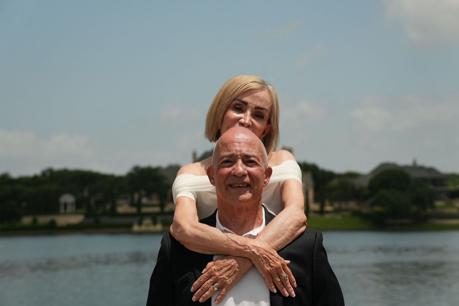 A happy couple share affectionate moments together while boating on a scenic lake.