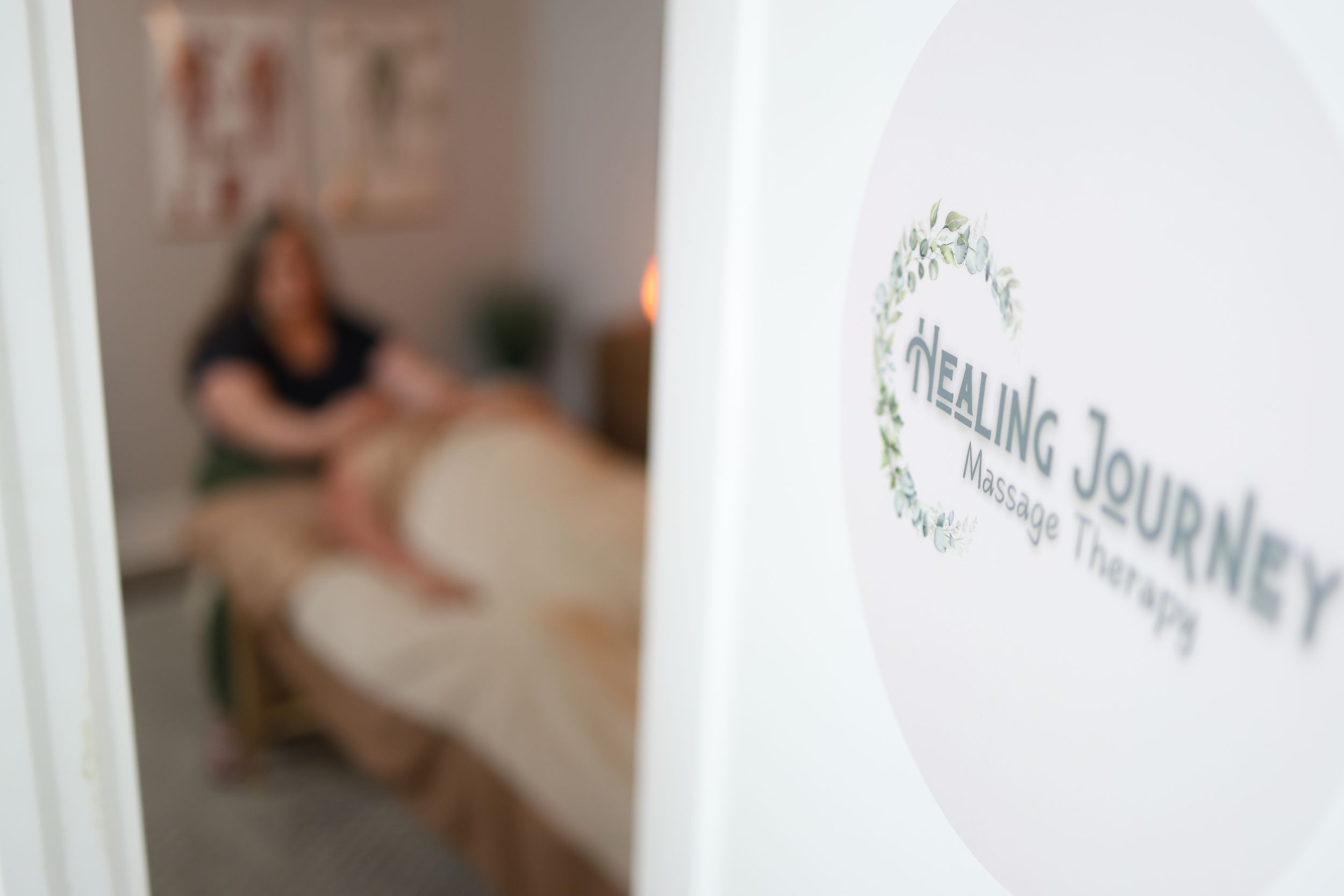 Three white healing journey banners hanging from ceiling create a peaceful wellness atmosphere in a light-filled space.