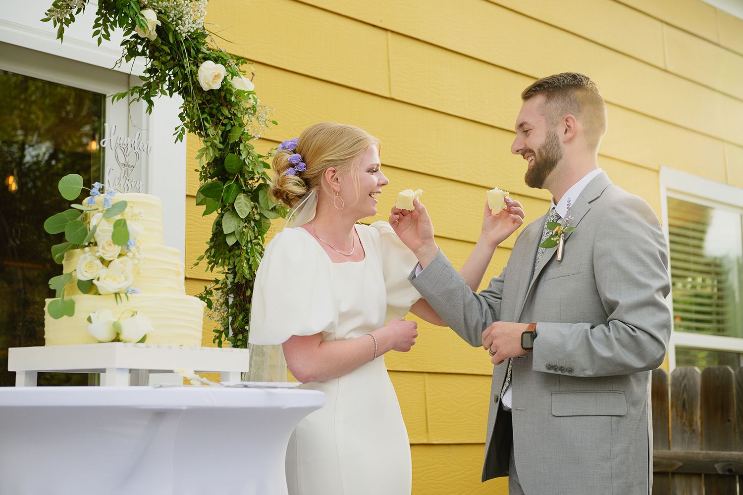 Blackfoot wedding photographer ShutterGirl cutting cake candid of bride and groom at backyard wedding in Blackfoot idaho