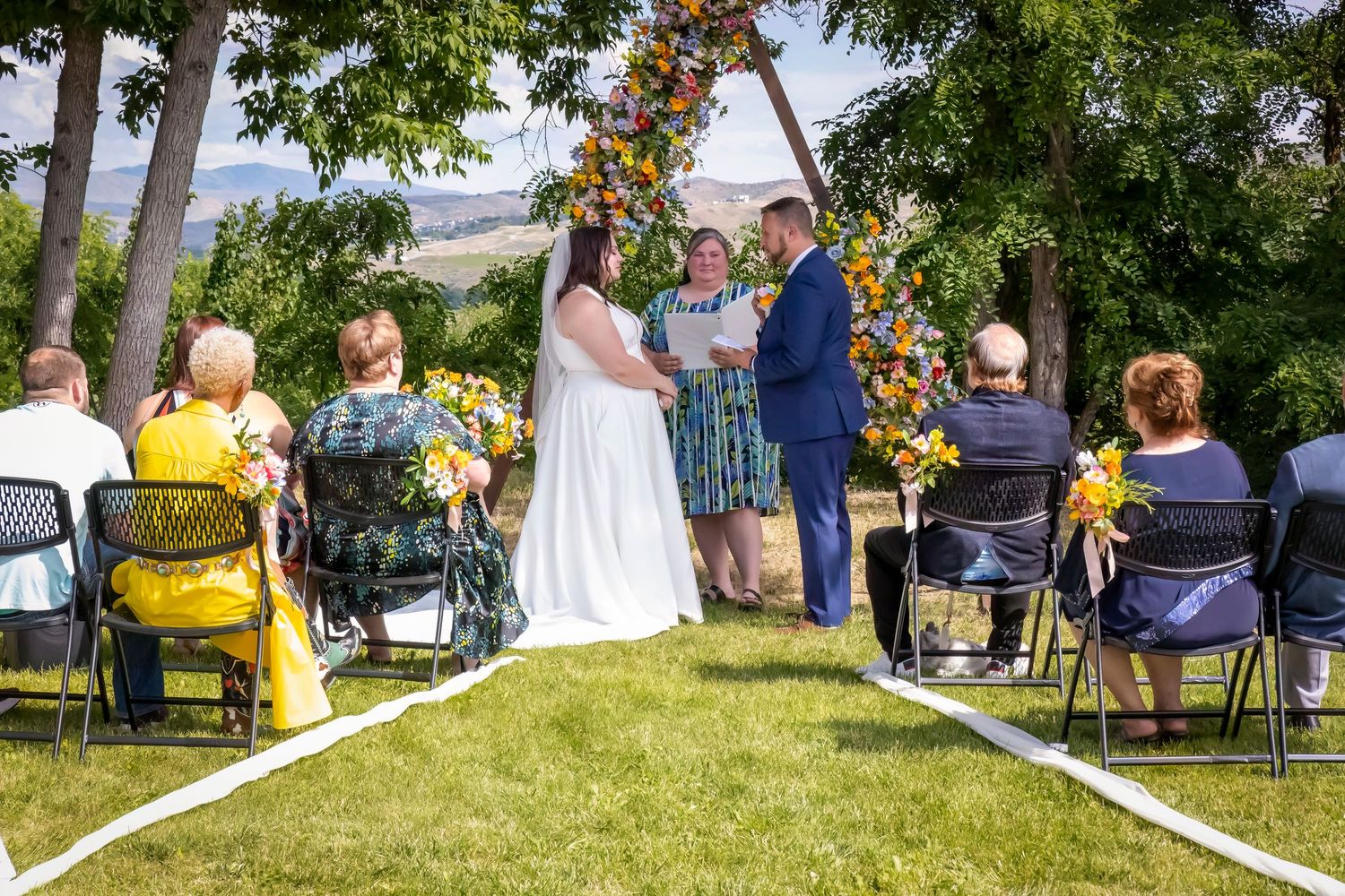 outdoor wedding bride and groom at end of aisle saying I DO with 12 guests