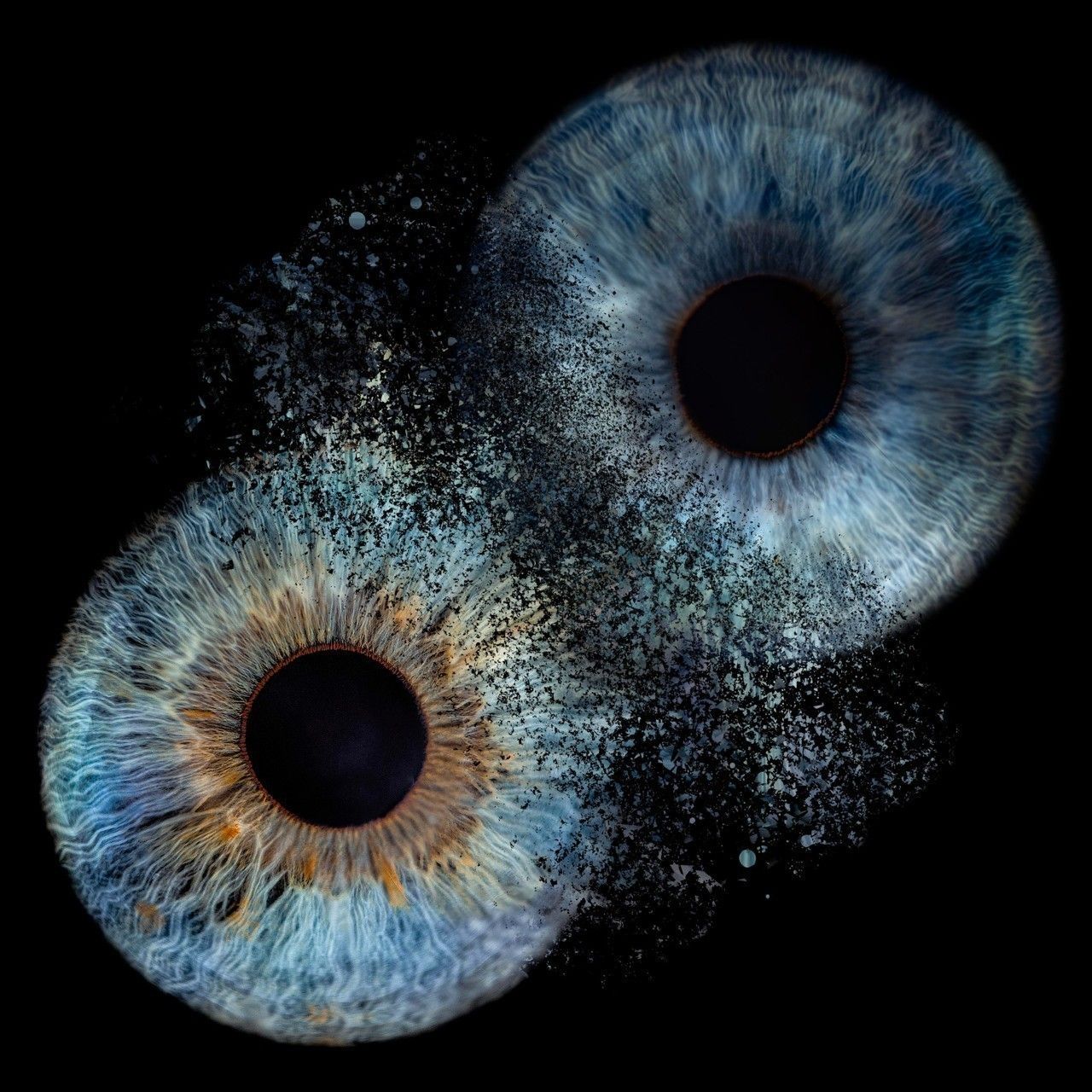 Artistic composite of two detailed blue and brown iris eyes disintegrating into particles against a black background.