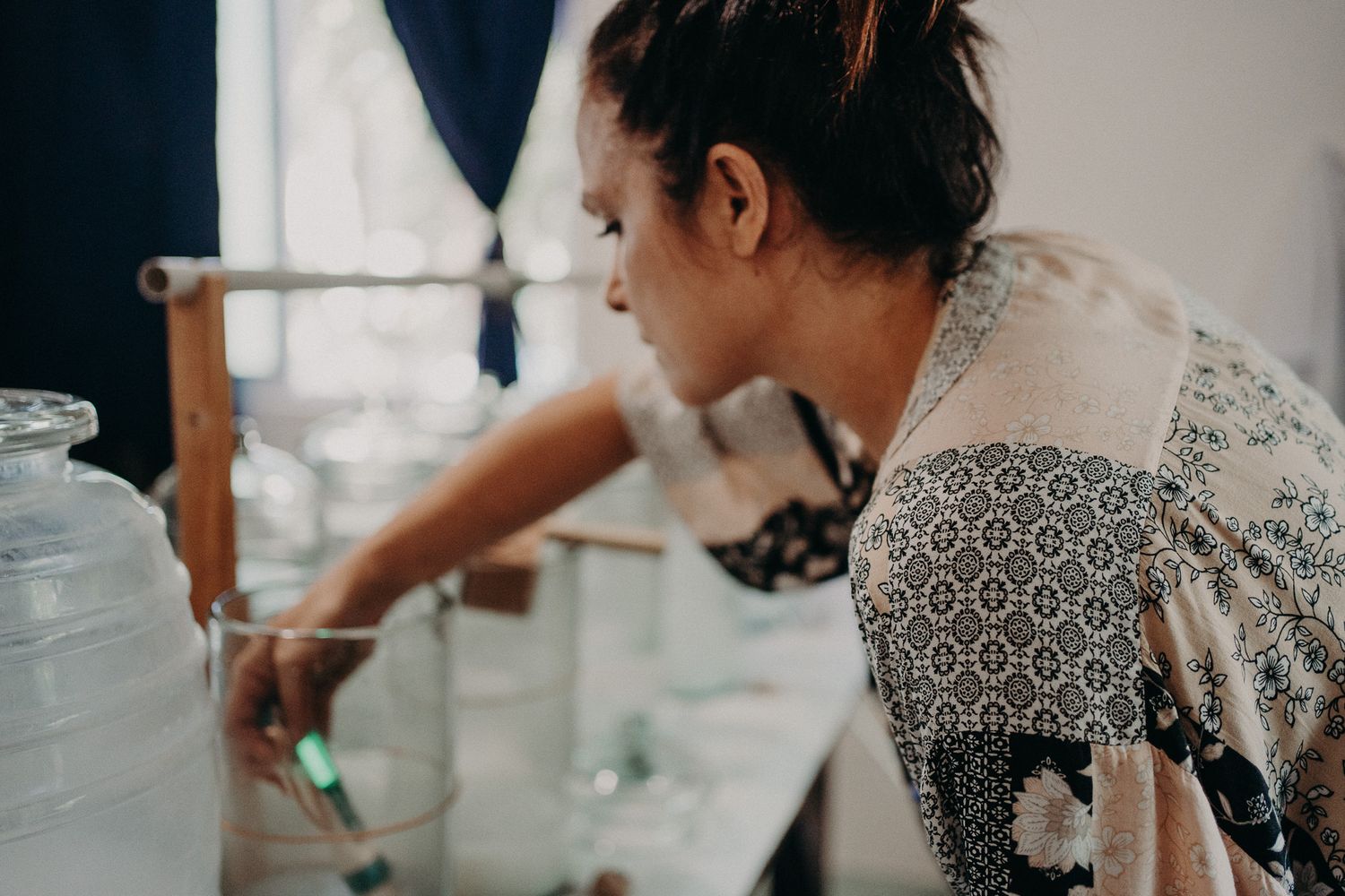 Person in patterned top carefully working with scientific measuring equipment.