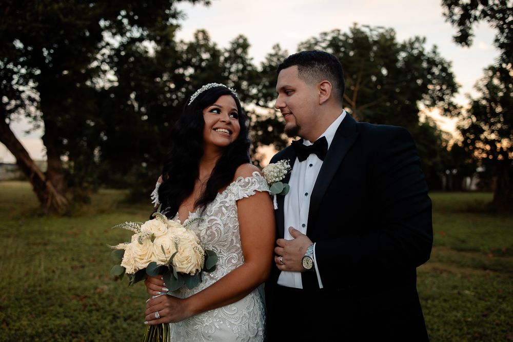 Happy couple shares intimate moment during outdoor sunset wedding ceremony.