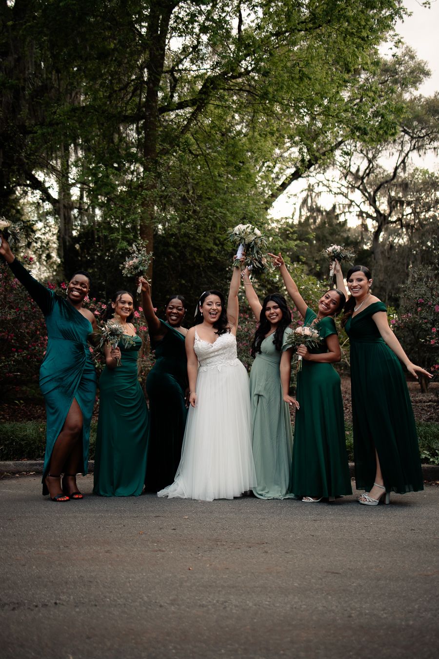 Wedding party celebrates with bridesmaids in elegant emerald green dresses.