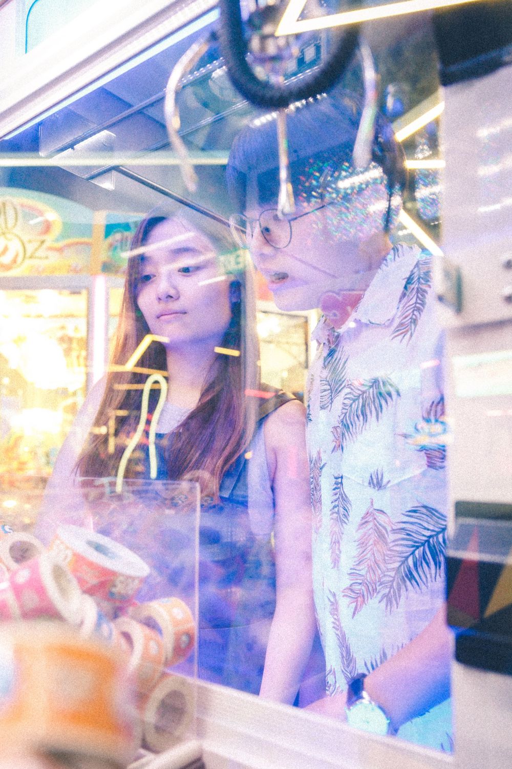 Artistic reflection shot through arcade glass with neon lights and palm print patterns.