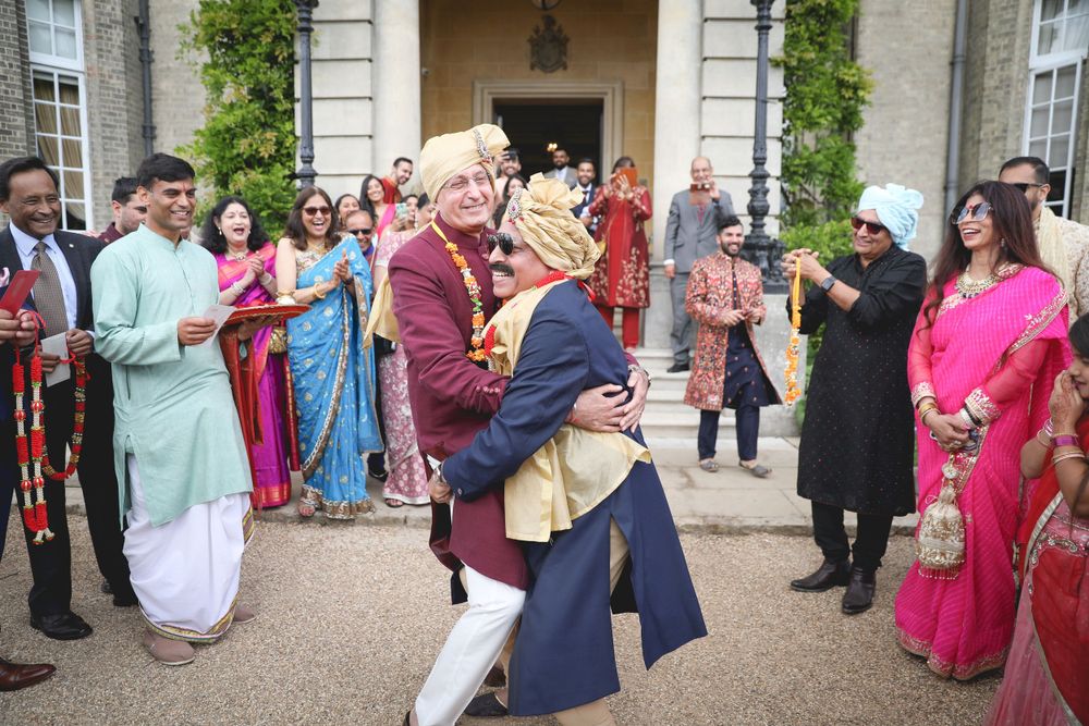 Traditional Indian wedding celebration with guests in colourful attire gathered outside a historic building. Hedsor House Wedding, Indian