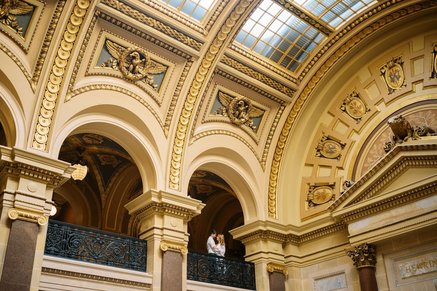 Ornate gold ceiling with architectural details and arches in historic building interior.