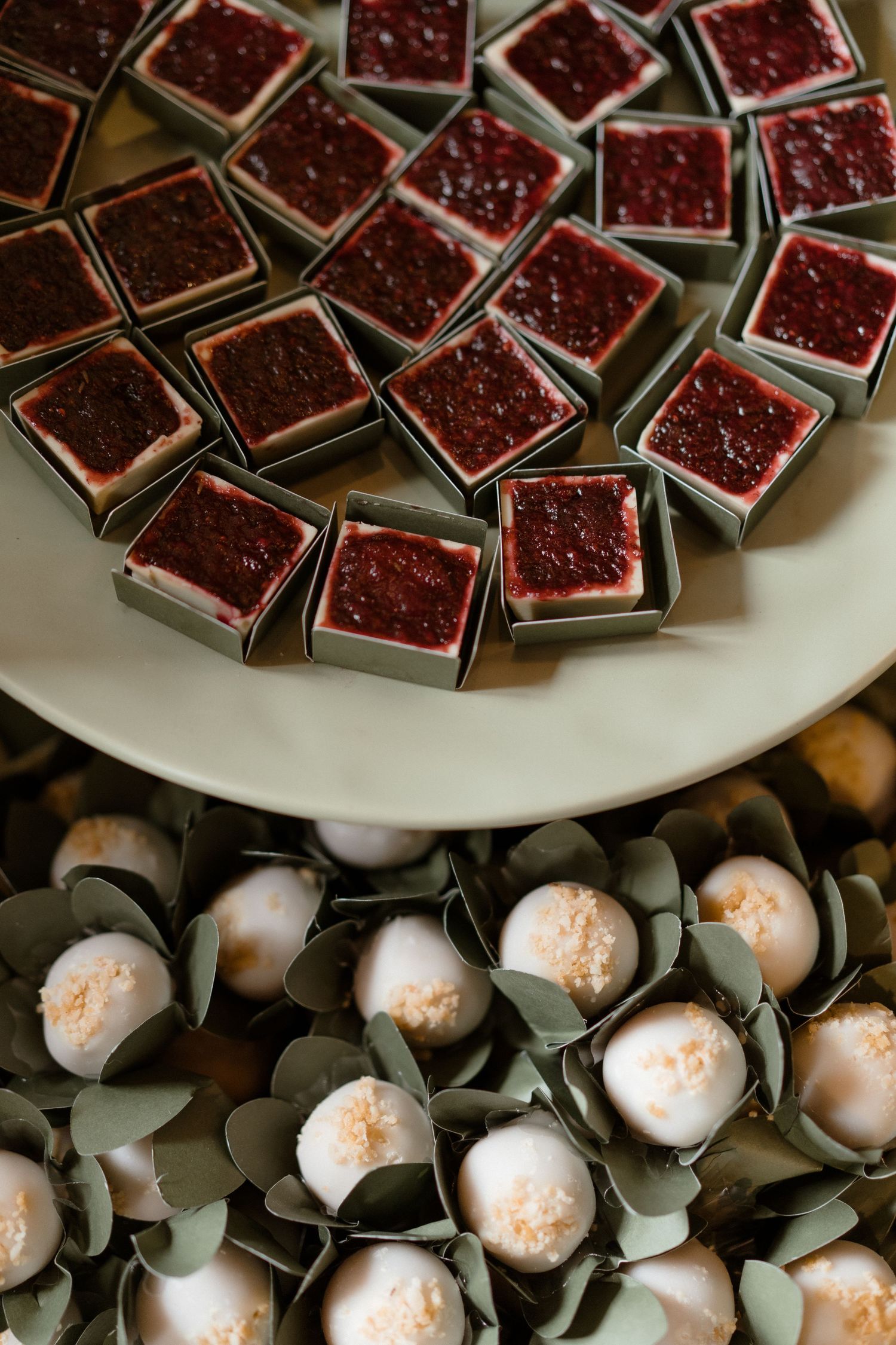 Plate of dark chocolate brownies and white truffles arranged on a dessert platter.
