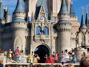 Costumed performers entertain visitors in front of Cinderella Castle at Walt Disney World's Magic Kingdom.