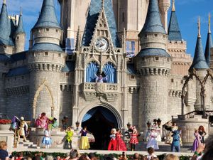 Performers entertain guests on stage in front of Cinderella Castle at Walt Disney World's Magic Kingdom theme park.