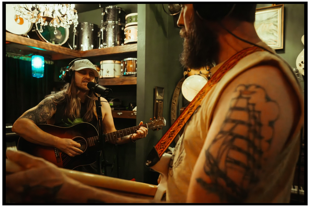 Musicians performing with acoustic instruments in a dimly lit room during an intimate jam session. Portland music photographer