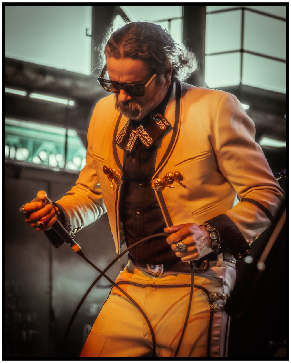 Performer in bright yellow suit jacket singing on stage with microphone. Portland music photographer