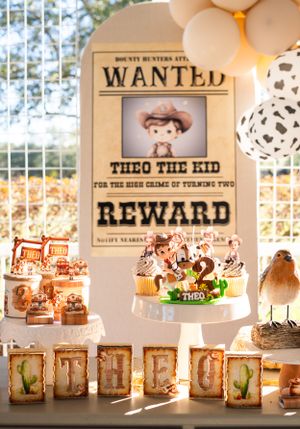 Rustic western party display with 'WANTED' posters and decorative table settings.