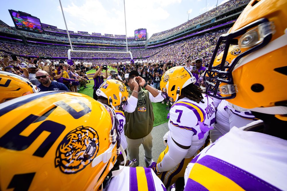 LSU football players and fans celebrate in Tiger Stadium during a game day atmosphere in Baton Rouge.