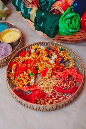 Decorative plate with red and gold wedding accessories and traditional Indian ceremonial items.