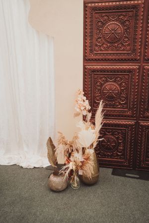Decorative wooden panels with carved geometric patterns alongside dried flower arrangements.