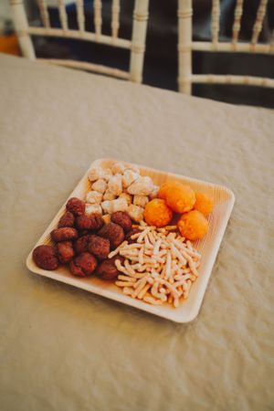 Party snack plate with fried appetizers including nuts, cheese sticks and meatballs.