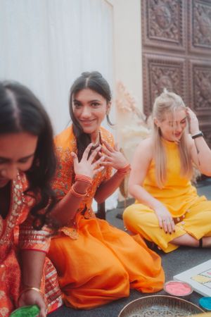 Celebratory gathering with people in vibrant orange and yellow traditional attire.